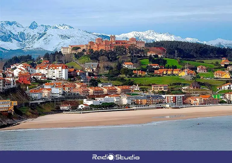 Vista panorámica de Comillas, con la playa en primer término y los Picos de Europa al fondo