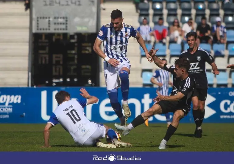 Javi Delgado y Basurto luchan por un balón ante el Langreo | Foto: Néstor Revuelta