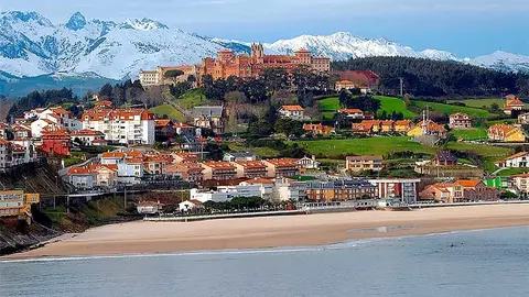 Vista panor&aacute;mica de Comillas, con la playa en primer t&eacute;rmino y los Picos de Europa al fondo