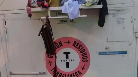 Un contenedor rebosado de ropa en Torrelavega | Foto: PP