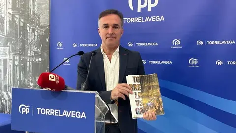 El concejal 'popular' Enrique G&oacute;mez sostiene la revista municipal de Torrelavega | Foto: Radio Studio