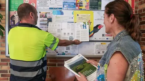 La alcaldesa, Rosa D&iacute;az, ayuda a un funcionario a colocar los carteles anunciadores de las jornadas informativas sobre el proyecto de hidr&oacute;geno verde en Polanco | Foto: Ayuntamiento