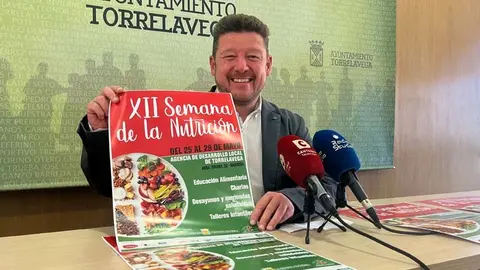Jes&uacute;s S&aacute;nchez posa con el cartel de la XII Semana de la Nutrici&oacute;n de Torrelavega | Foto: Radio Studio